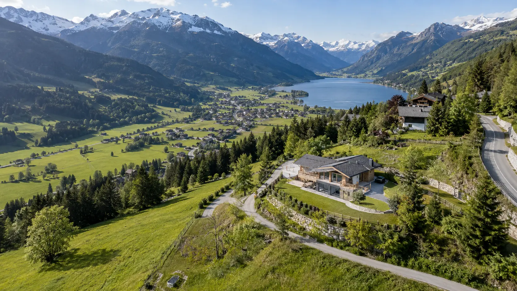 Chalet in weiter alpiner Landschaft aus großer Drohnenhöhe